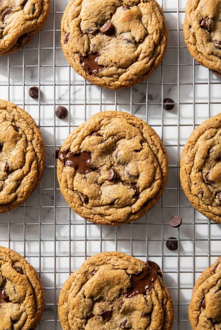 Close-up of chewy chocolate chip cookies with golden edges on a cooling rack