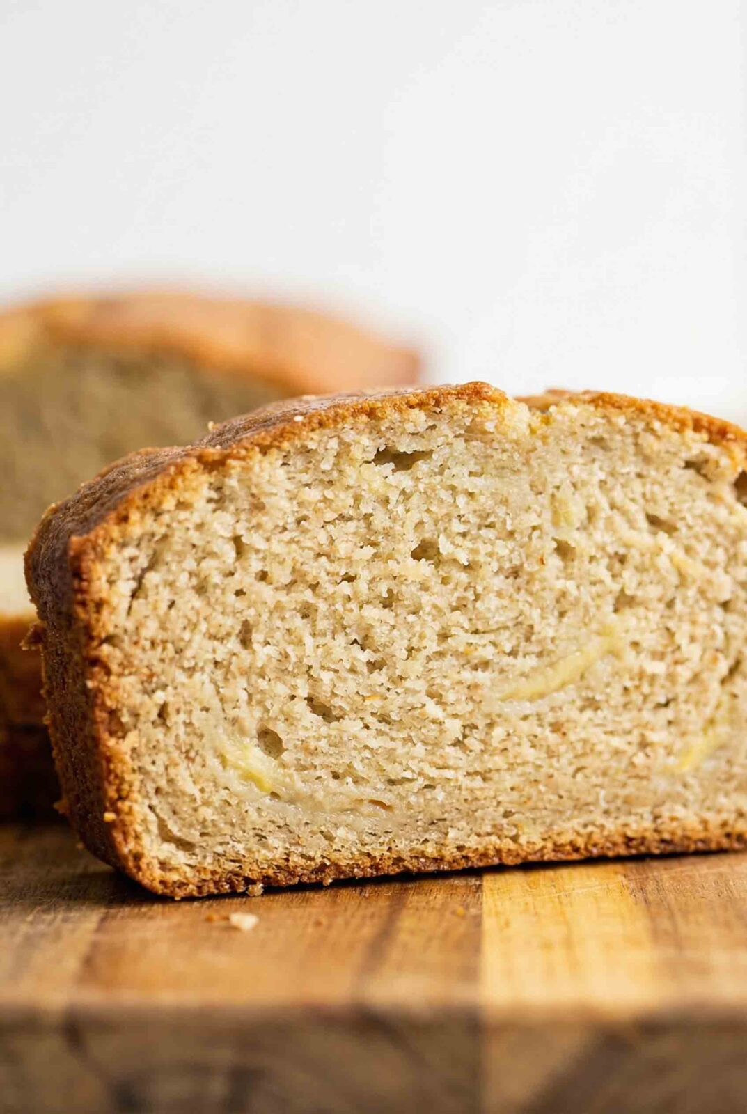 Close-up slice of almond flour banana bread showing tender, moist crumb with fine grain texture and flecks of mashed banana