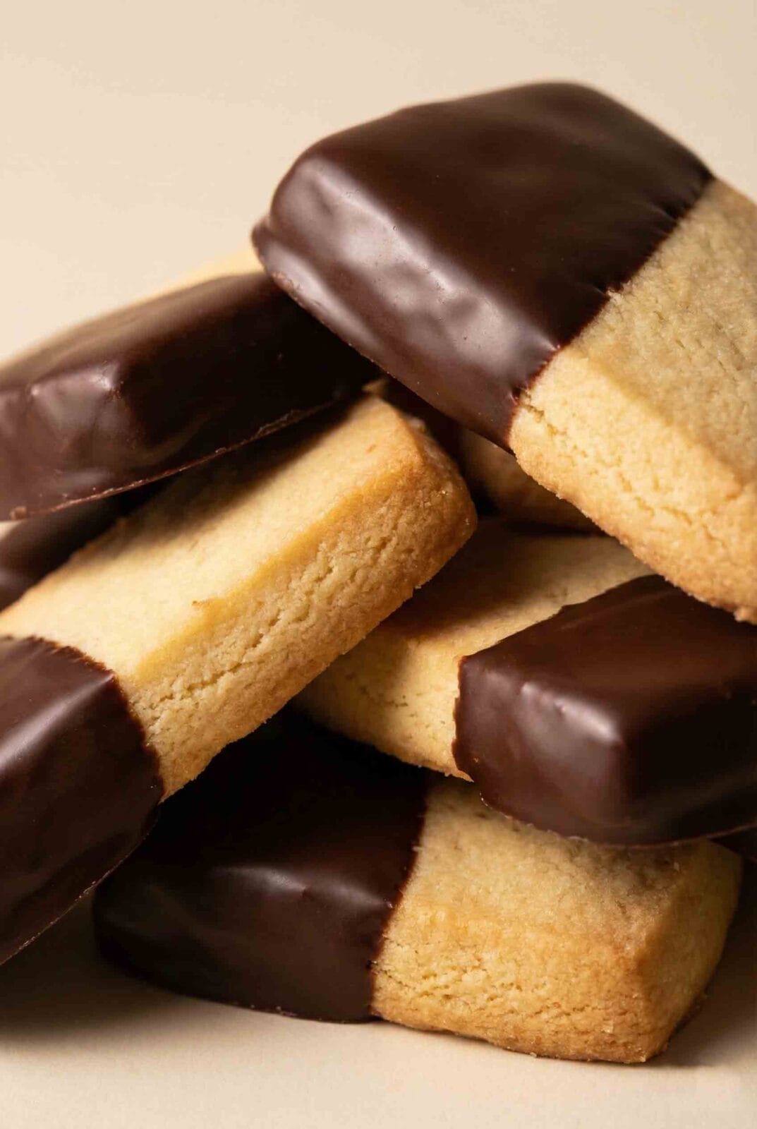 Close-up of chocolate dipped shortbread cookies showing buttery crumb texture and glossy dark chocolate coating