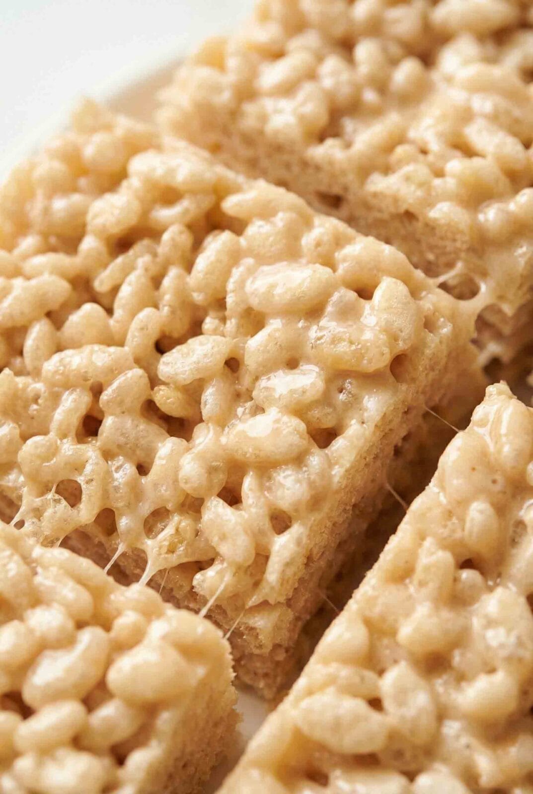 Classic Rice Krispie Treats showing glossy melted marshmallow stretching between puffed rice cereal squares with a soft chewy texture