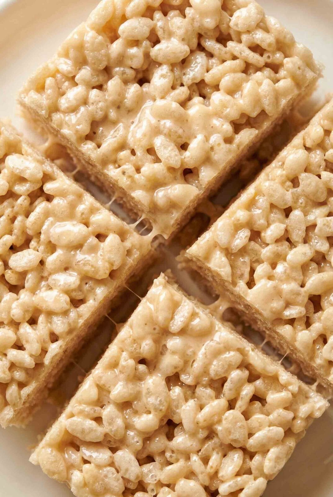 Classic Rice Krispie Treats cut into neat squares, coated in shiny marshmallow with airy puffed rice texture and clean edges