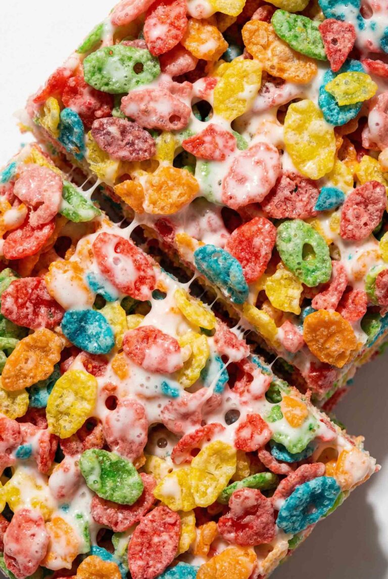 Fruity Pebbles Rice Krispie Treats with rainbow cereal coated in glossy marshmallow, bold colors, crisp texture, and dense chewy structure
